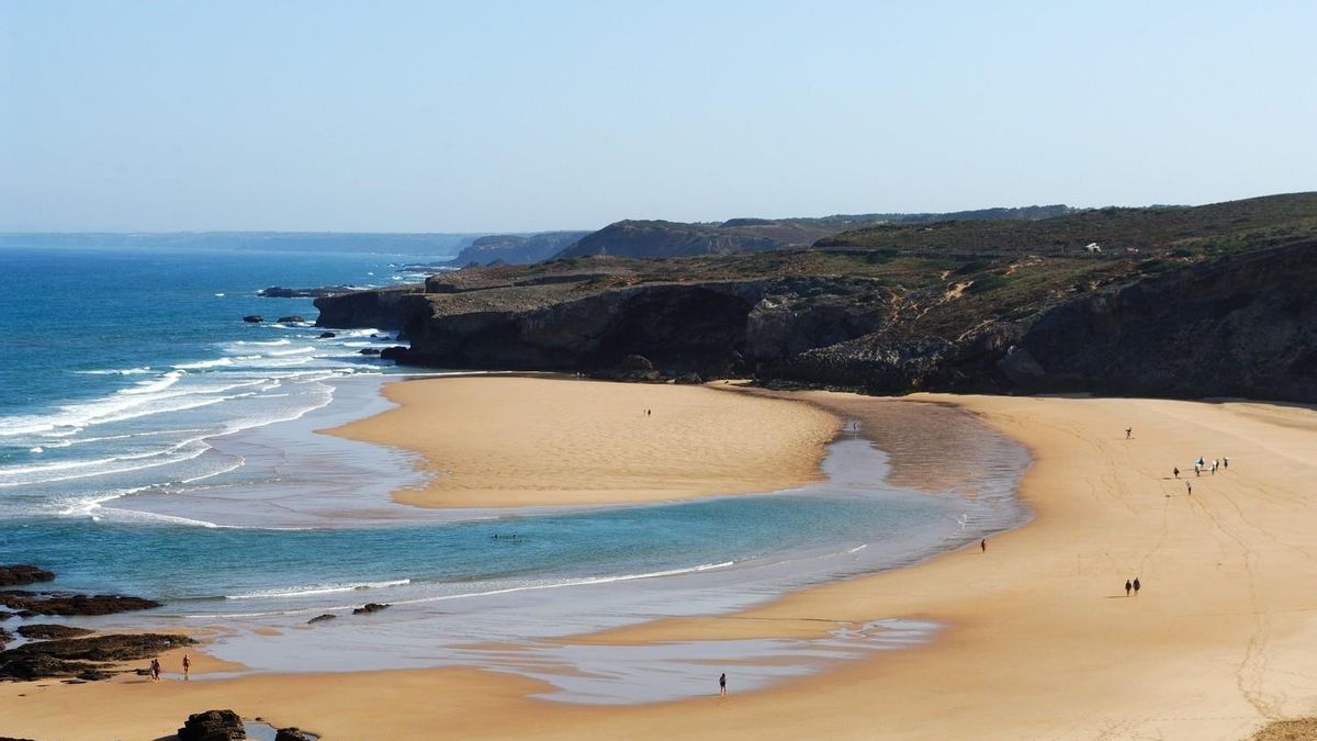 La espectacular playa salvaje de arena dorada y rodeada de acantilados, dunas y perfecta para hacer surf en Portugal