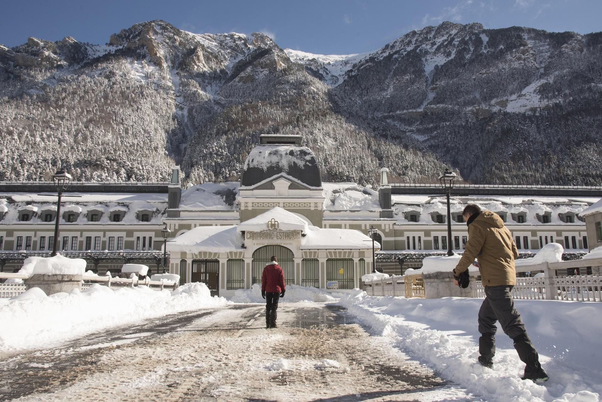 Varias personas caminan por la antigua estación de tren de Canfranc, en Huesca, cubierta por nieve