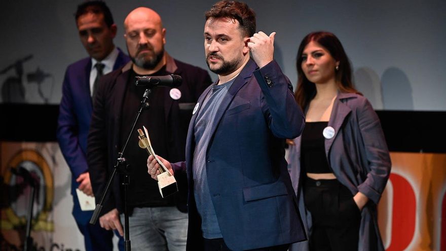 Nacho Arias, al fondo, observa a Juan Carlos Mostaza recibiendo el Roel por 'Humbug Manor'.