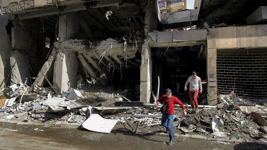 Dos hombres salen corriendo del interior del edificio Qard al-Hassan, la institución financiera del grupo proiraní Hezbolá, en el centro de Beirut.