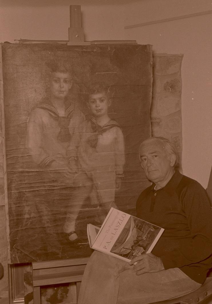 El pintor posa junto a una de sus obras, sujeta en un caballete de madera.