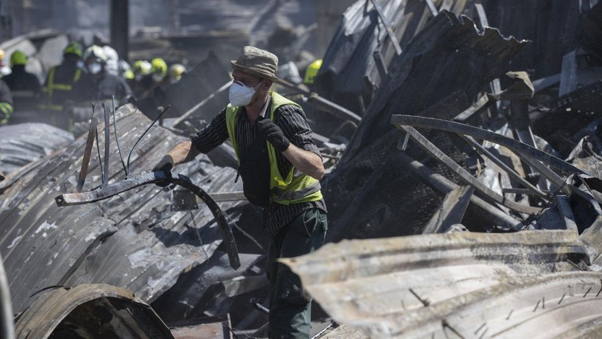 Decenas de bomberos y miembros de los equipos de rescate continúan trabajando en el centro comercial de la ciudad de Kremenchuk que fue atacado con misiles rusos y donde, hasta ahora, se han contabilizado 18 muertos y 36 desaparecidos, este martes en Kremenchuk (Ucrania). EFE/Orlando Barría