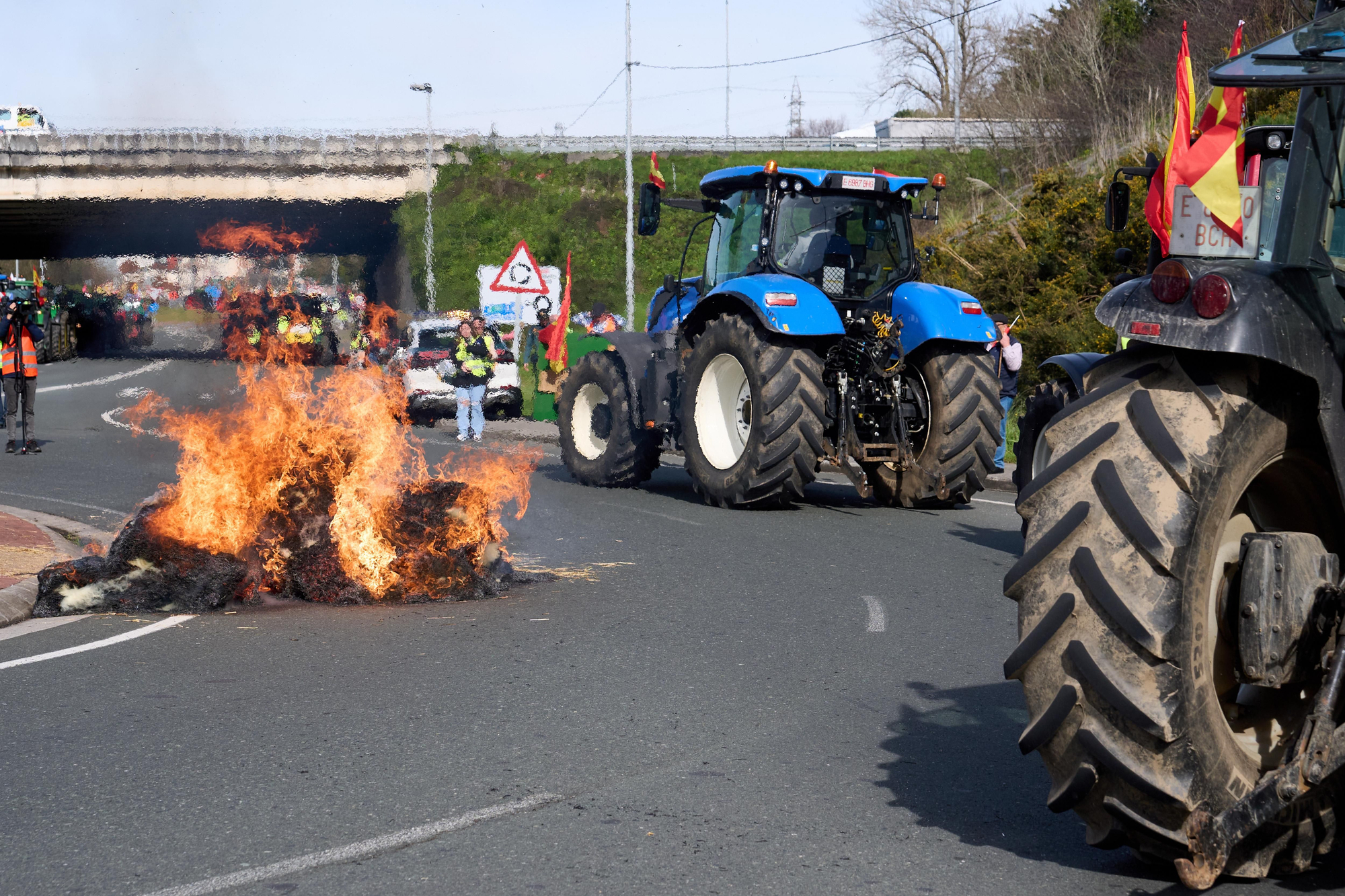 Los ganaderos han arrojado pacas de paja y las han prendido fuego junto a las rotondas de acceso a la autovía.