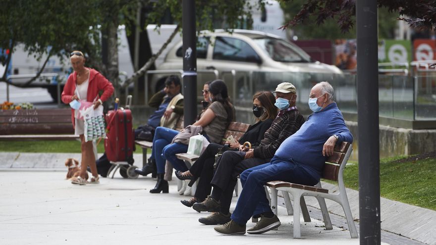 Archivo - Varias personas sentadas con mascarillas en un parque de Santander