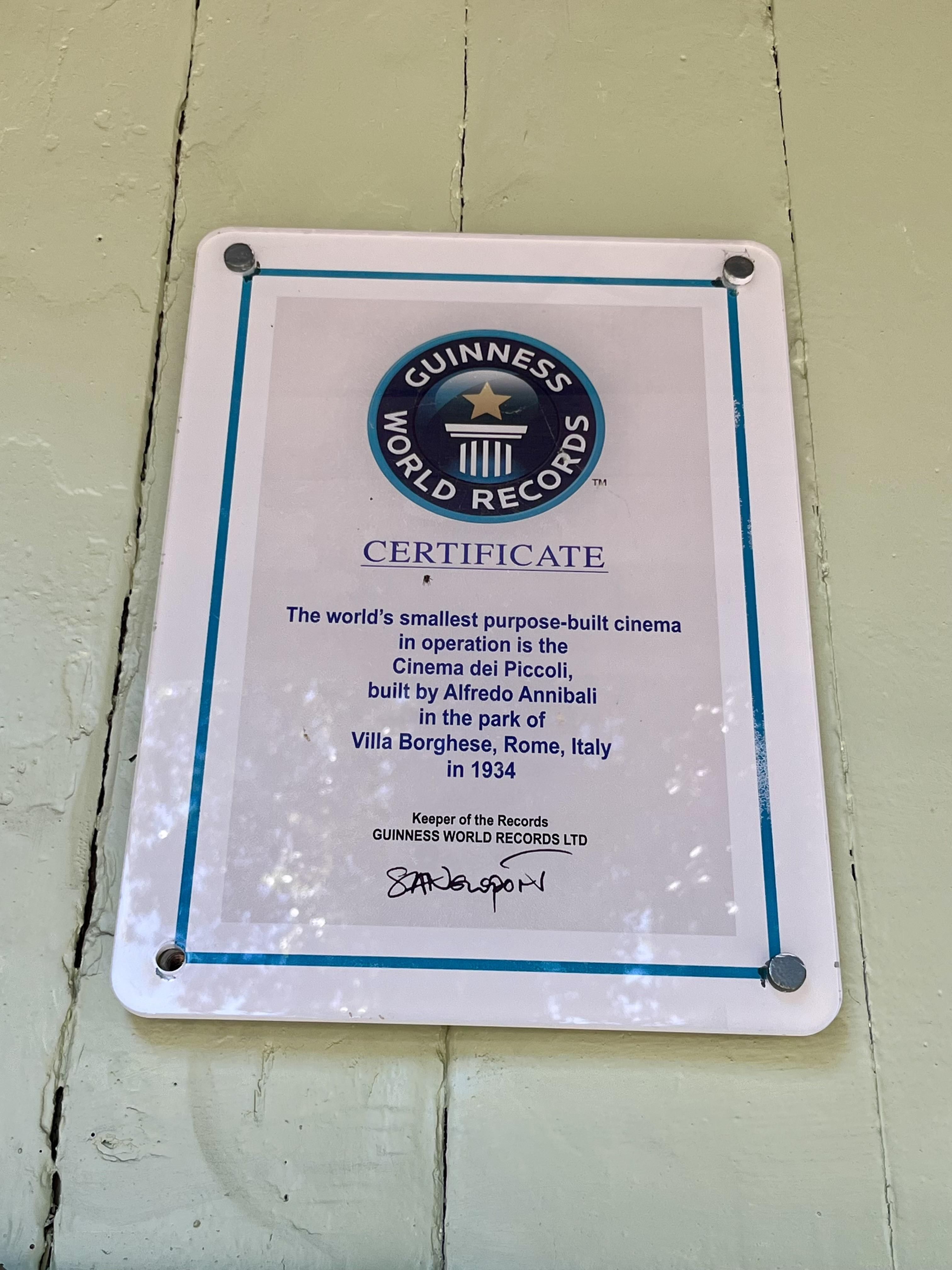 Placa en la fachada de Cinema dei Piccoli que certifica el récord Guinness como edificio construido como sala de cine más pequeño del mundo.