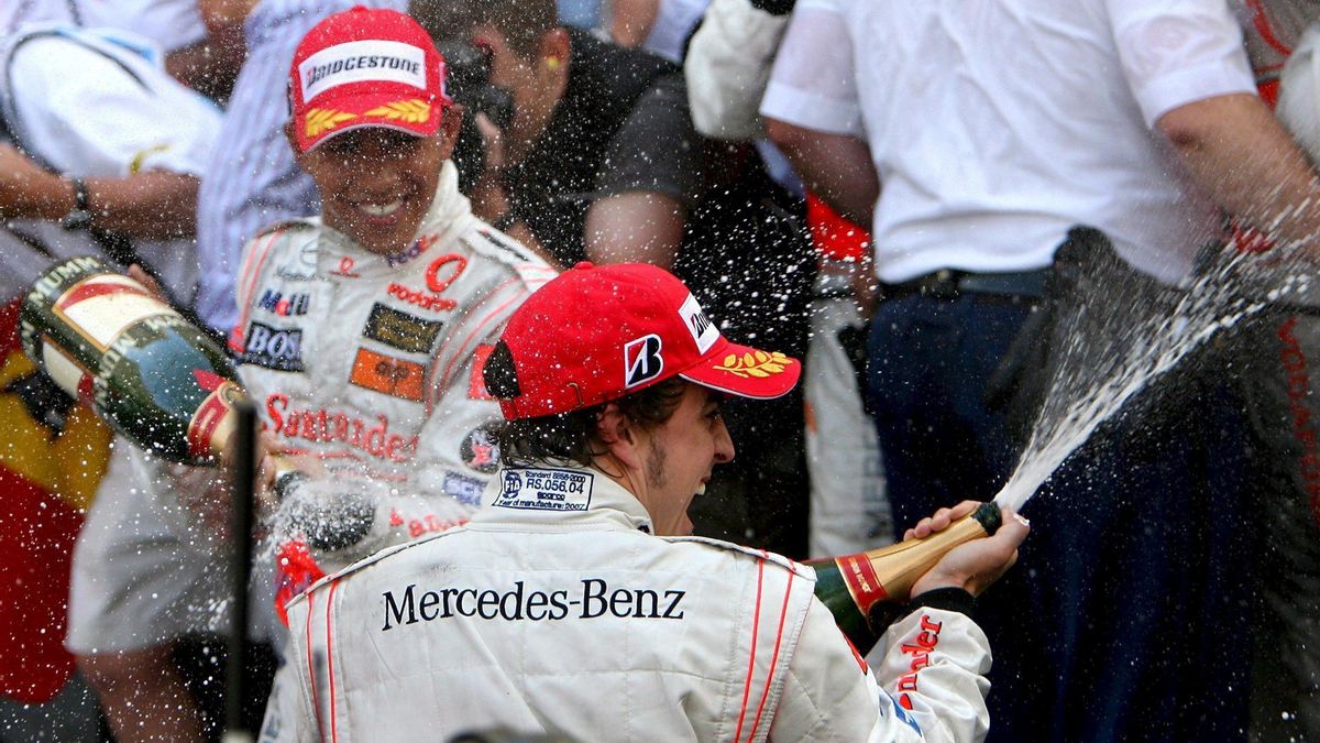 El piloto español Fernando Alonso de McLaren Mercedes (de espaldas) muestra su alegría en el podio junto a su compañero de escudería, el británico Lewis Hamilton (i), tras el Gran Premio de Fórmula Uno de Mónaco en Montecarlo celebrado domingo 27 de mayo. Alonso fue primero y Hamilton segundo.