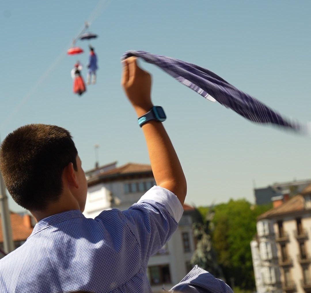 Un niño, ondeando un pañuelo a cuadros