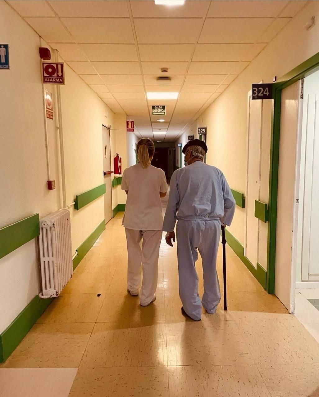 Una profesional sanitaria en el área de geriatría del Hospital Virgen del Valle de Toledo junto a un paciente