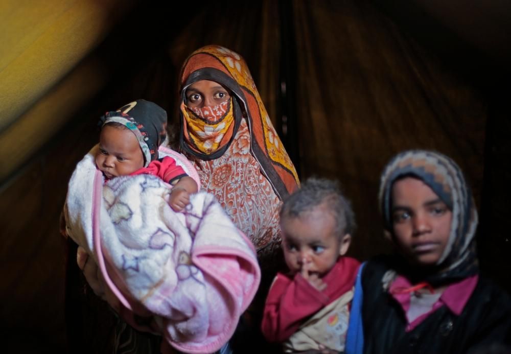 Um Abdulramán sostiene a su hijo el pasado 20 de febrero de 2016, nacido durante la guerra y ahora desplazado en el campamento de los desplazados khmer en Amran, en el noroeste de Yemen. La familia tuvo que abandonar su hogar para escapar de los constantes ataques aéreos en la provincia septentrional de Saada. © Rawan Shaif