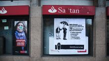 Cartel de protesta por los desahucios en una sucursal del Banco Santander en Barcelona. / ANDREA BOSCH.
