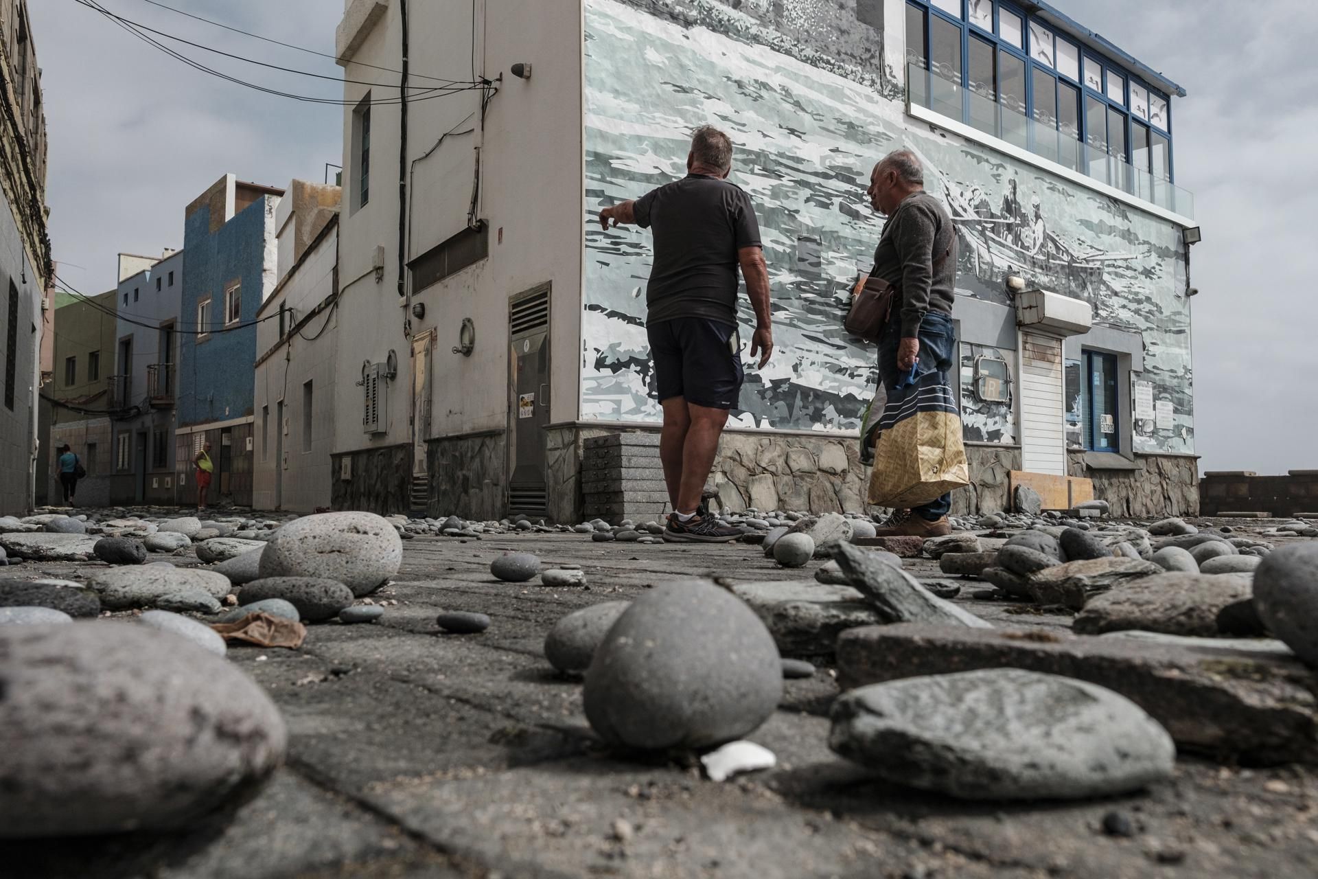 Vecinos, limpiando los desperfectos del mar en el barrio marinero de San Cristóbal.