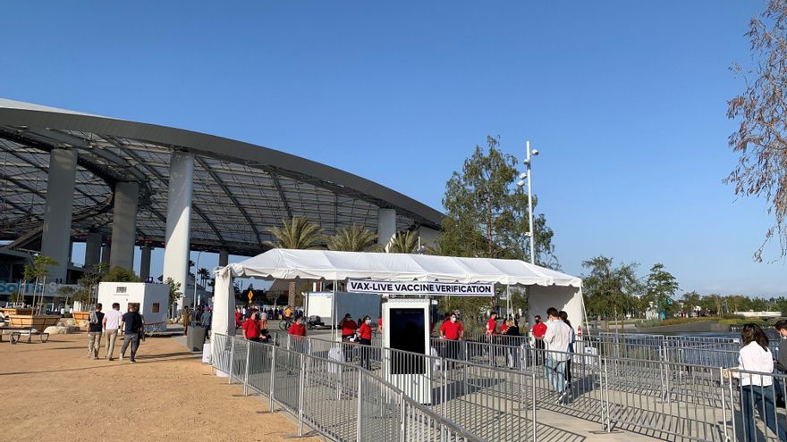 Unas personas pasan por la carpa de verificación de vacunados por covid a su llegada este domingo al concierto "Vax Live", el primer gran evento musical celebrado en EE.UU. desde el inicio de la pandemia, celebrado en el SoFi Stadium de Inglewood, en el condado de Los Ángeles, California. EFE/Javier Romualdo