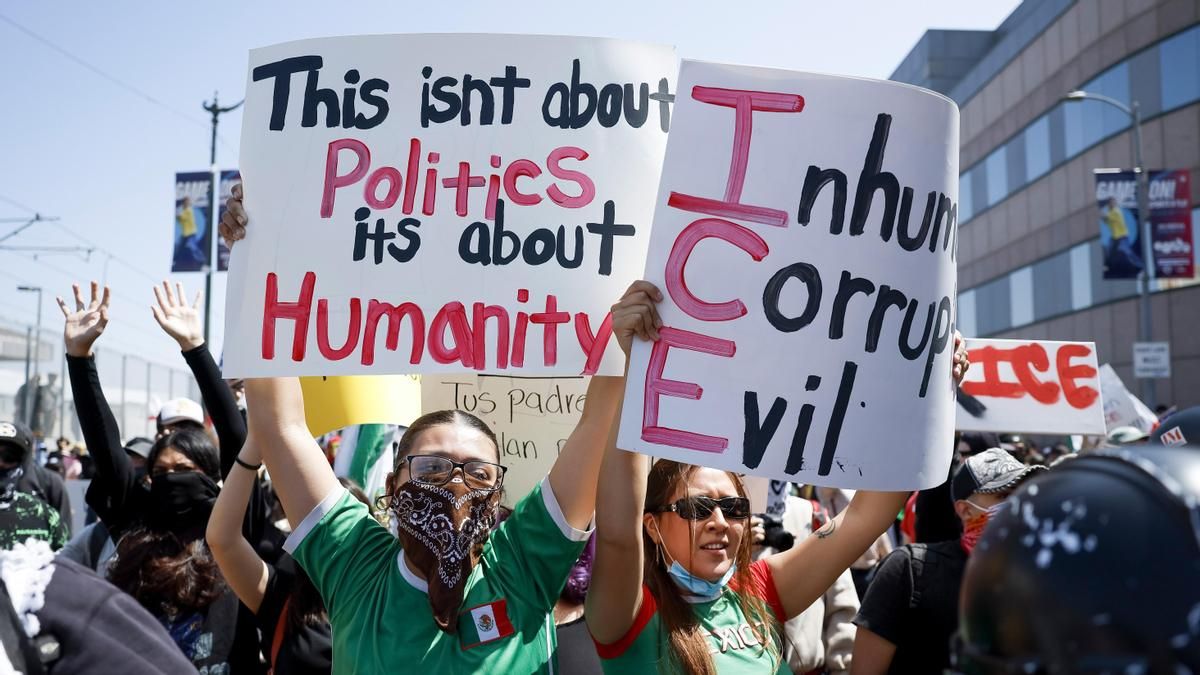 Manifestantes contra las deportaciones de migrantes portan carteles críticos con la agencia ICE en Los Ángeles en junio.