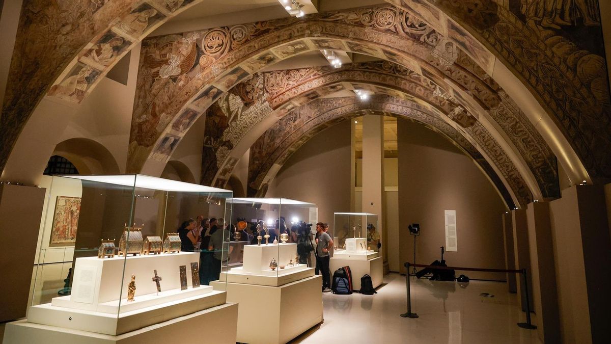 Varias personas observan las pinturas murales del Monasterio de Sijena expuestas en el MNAC