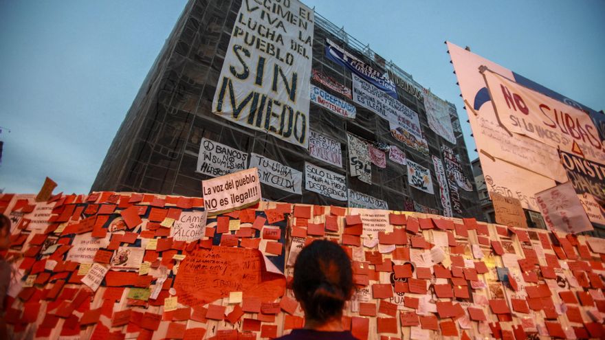 22/05/2011. Una joven observando los carteles reivindicativos que los "indignados" colocaron en un edificio en obras en la Puerta del Sol.