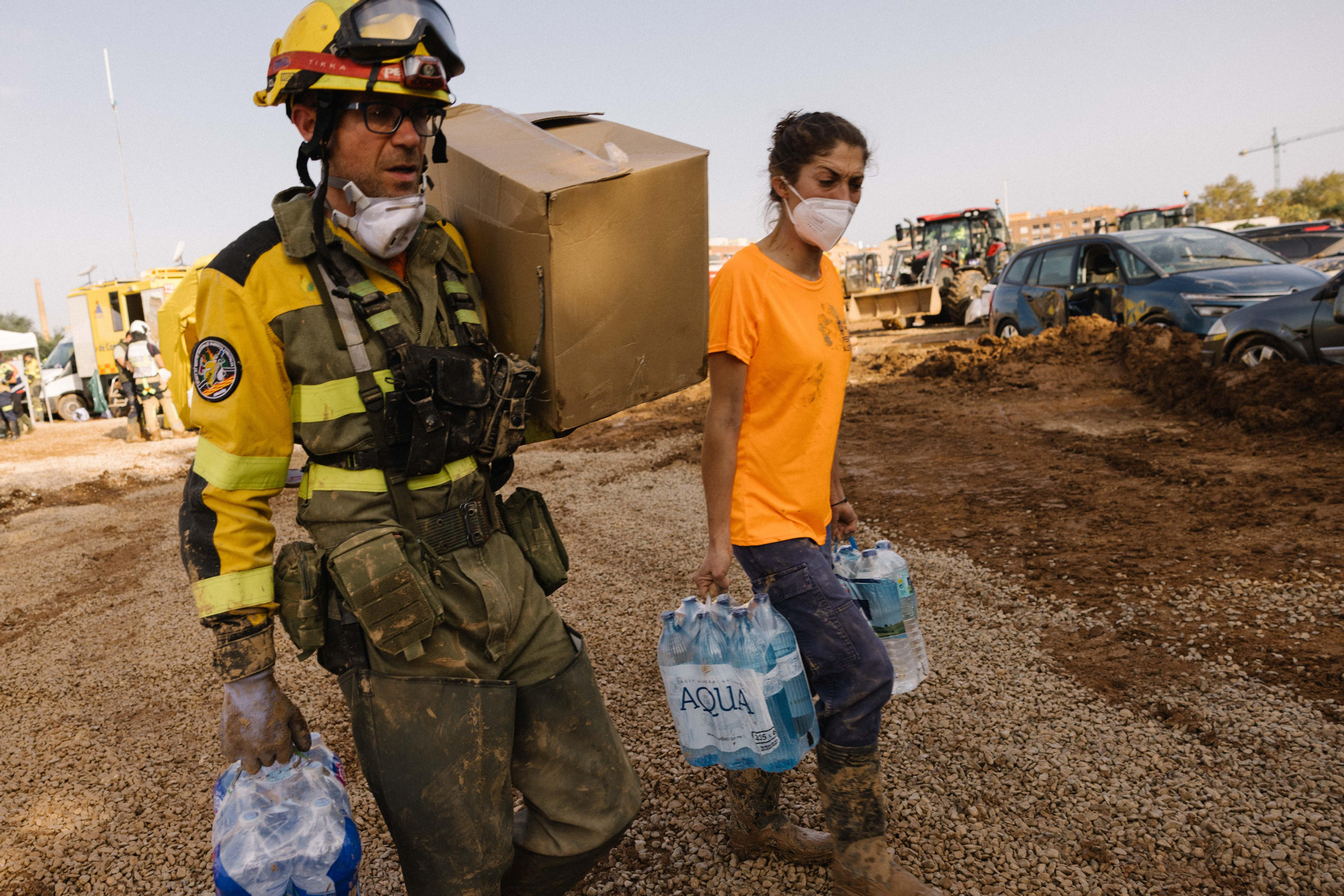 Efectivos del Gobierno de Aragón cargando agua junto a una vecina en Catarroja