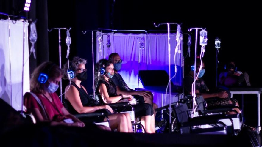 Una de las escenas de la obra de teatro en la que el público se sienta en sillas de ruedas