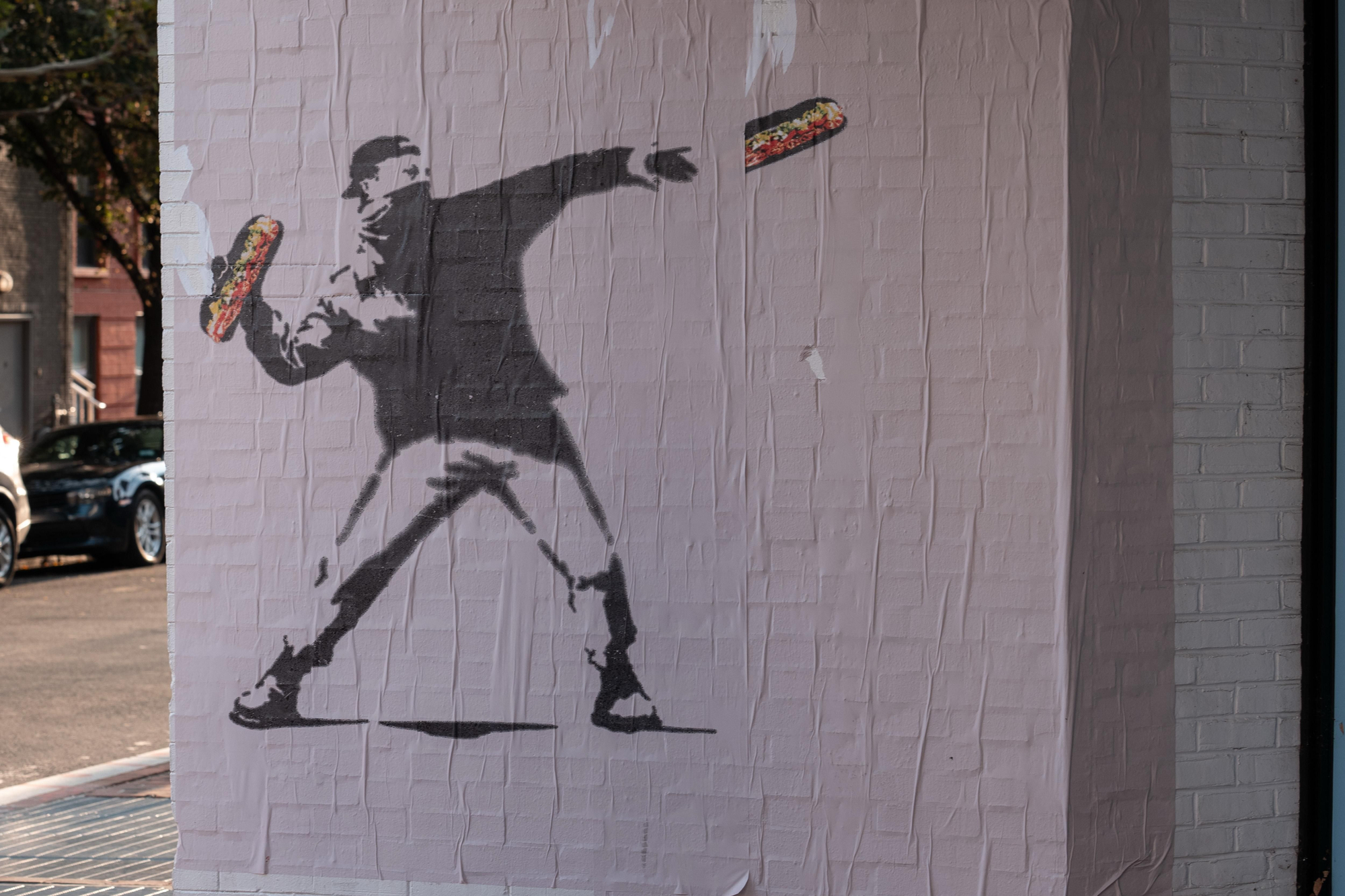 Carteles al estilo Banksy que muestran a un manifestante lanzando un sándwich al secretario de Defensa, Pete Hegseth, el 31 de agosto de 2025 en Washington, DC, inspirados en Sean Dunn, conocido como el "Hombre del Bocadillo".