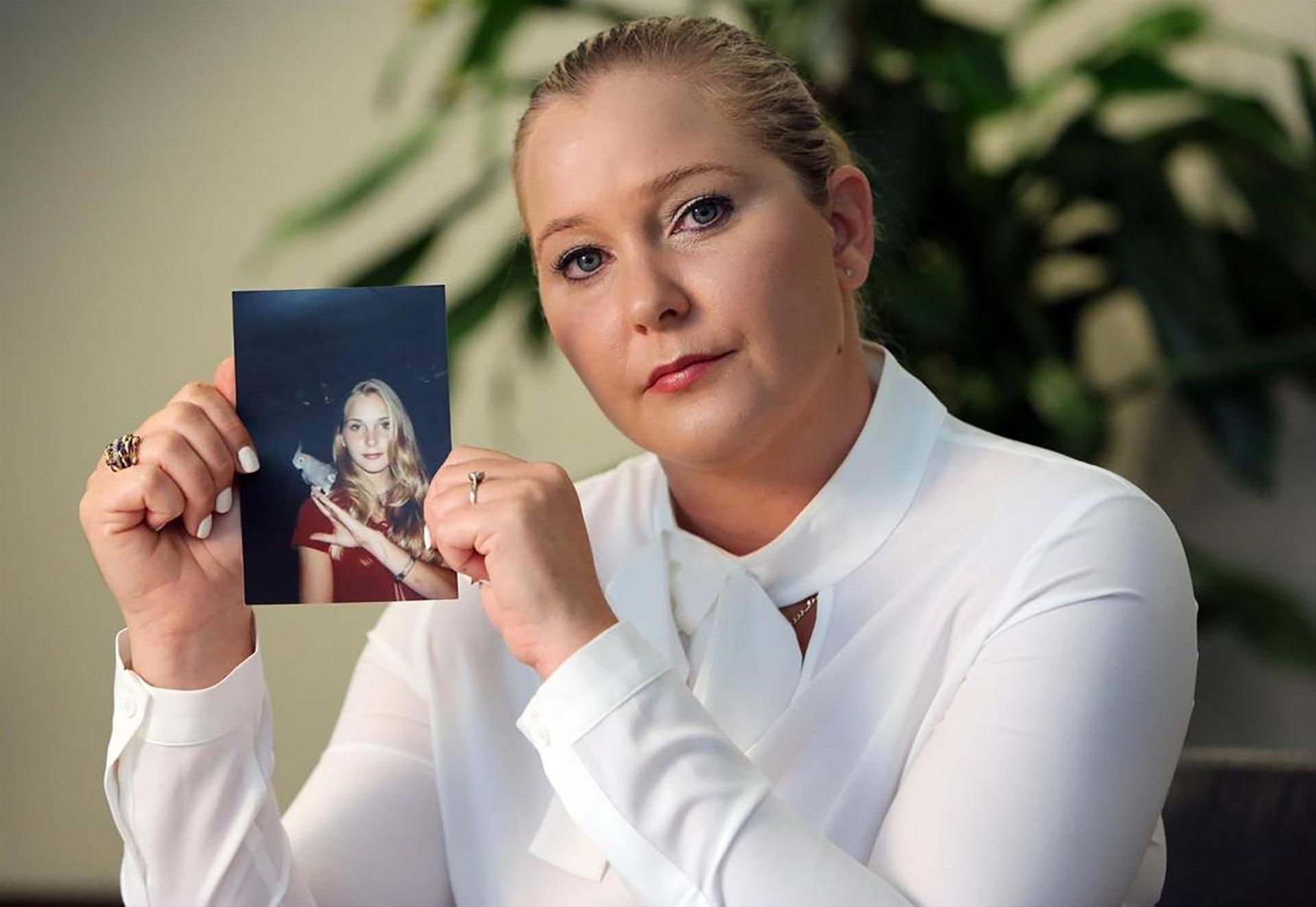 Virginia Roberts Giuffre, con una foto de ella misma cuando era adolescente, en una imagen de septiembre de 2022.