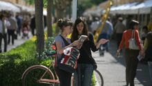 Dos joves repassen un volum a la Fira del Llibre de València.