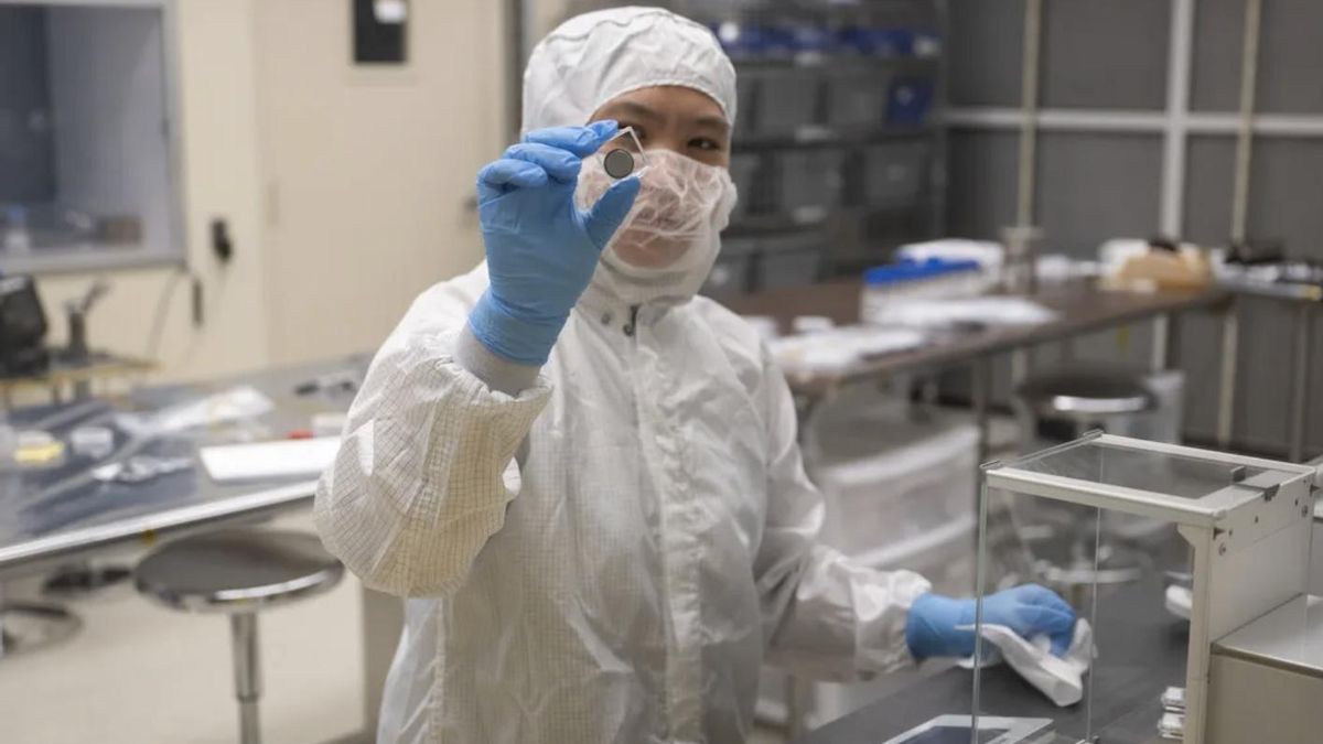 Nike Lin, ingeniero/técnico de soporte del equipo de vacío térmico, toma medidas de peso de las baterías después de las pruebas de vacío térmico