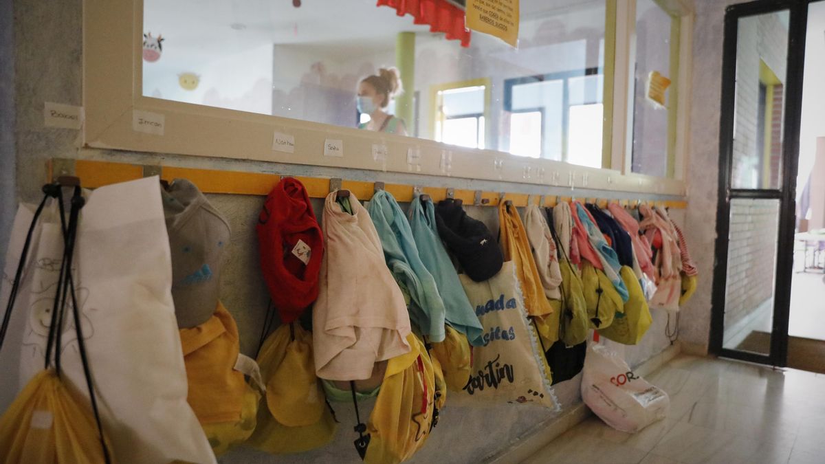Chaquetas de los alumnos colgadas en la pared de una Escuela Infantil, foto de archivo