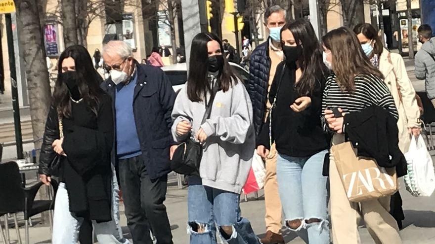 Jóvenes con mascarilla pasean por la calle