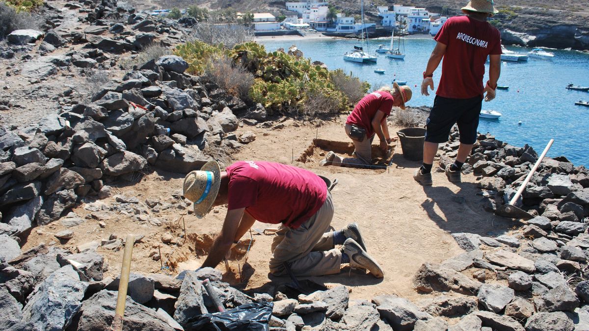 Arqueólogos excavan en uno de los yacimientos del Puertito de Adeje. En la parte superior, junto a la playa, se aprecia el antiguo almacén de plátanos. Arqueocanaria
