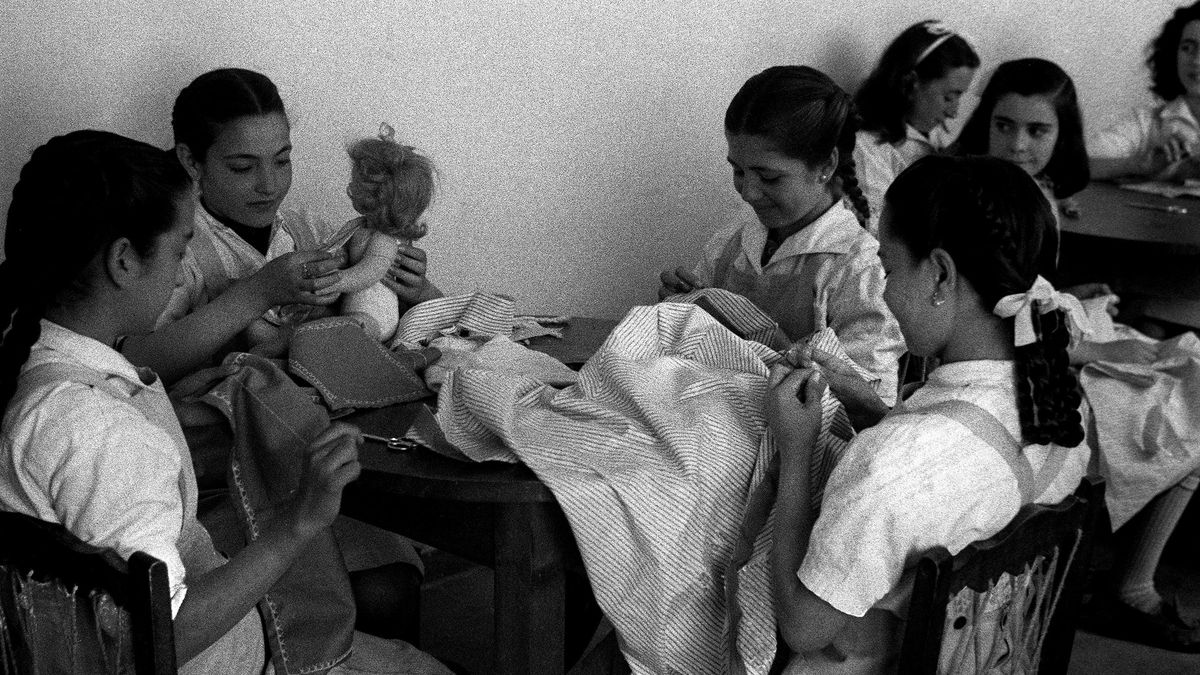 Chicas confeccionan muñecas en una Escuela Taller de la Sección Femenina en Madrid. Abril de 1948.