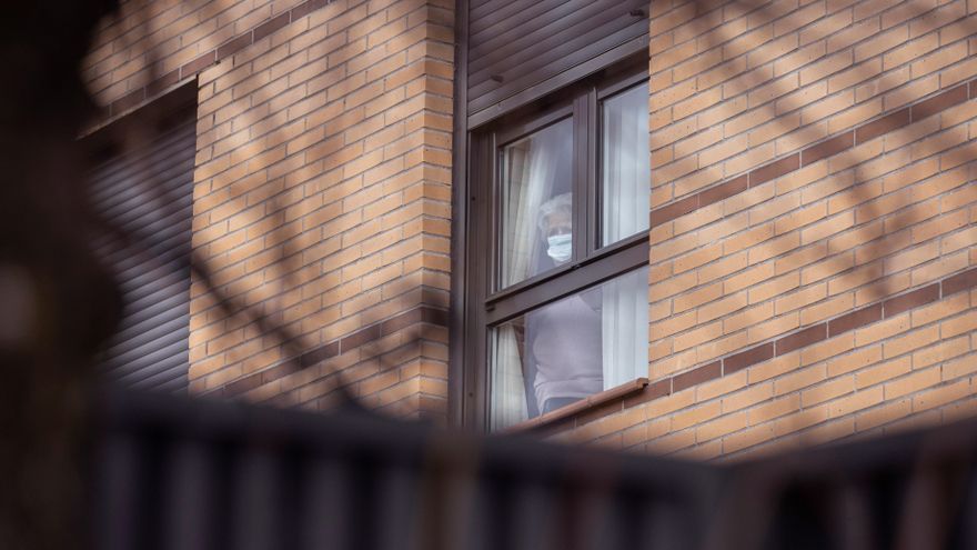 Una residente observa desde el interior de la residencia para mayores Vigor de la localidad madrileña de Becerril se la Sierra, este viernes, después de que once ancianos hayan fallecido, posiblemente por la cepa británica, tras detectarse un brote que ha afectado a sus 17 trabajadores y a sus 48 residentes, 65 positivos en total. EFE/Rodrigo Jiménez