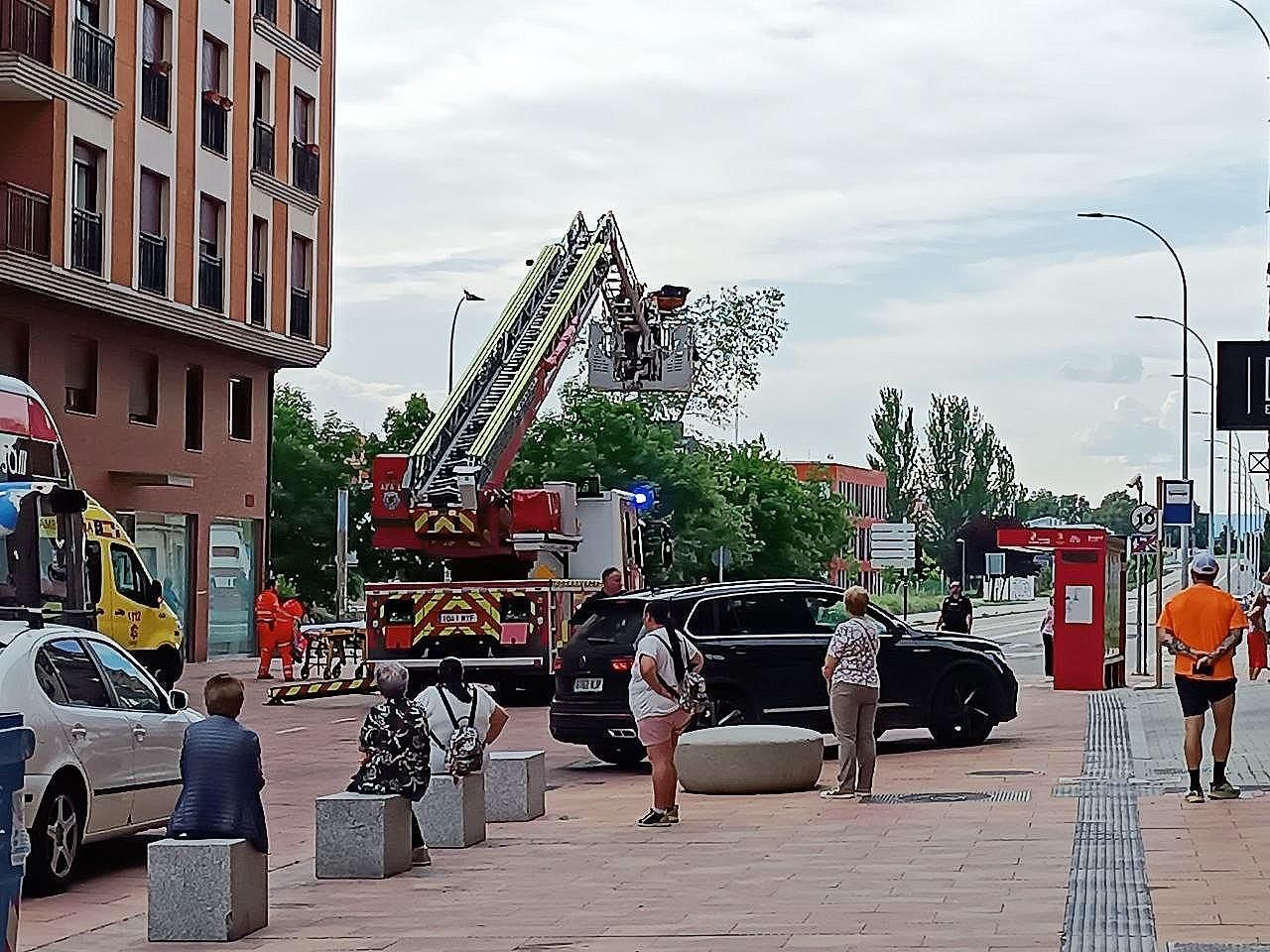 La grúa extensible de los Bomberos de León comenzando la maniobra observada por los vecinos.