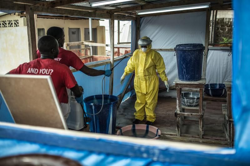 Cuando un trabajador sanitario sale de la zona de riesgo, se higieniza con agua con cloro bajo la supervisión de dos personas más. Se emplean cerca de 10 litros de agua clorada para este proceso. Fotografía: Pablo Tosco/ Oxfam Intermón