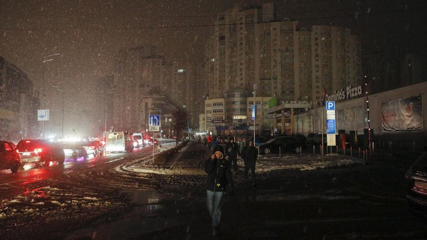 Varios ciudadanos caminan por Kiev después de que un ataque ruso cortara el suministro eléctrico el viernes 16 de diciembre.