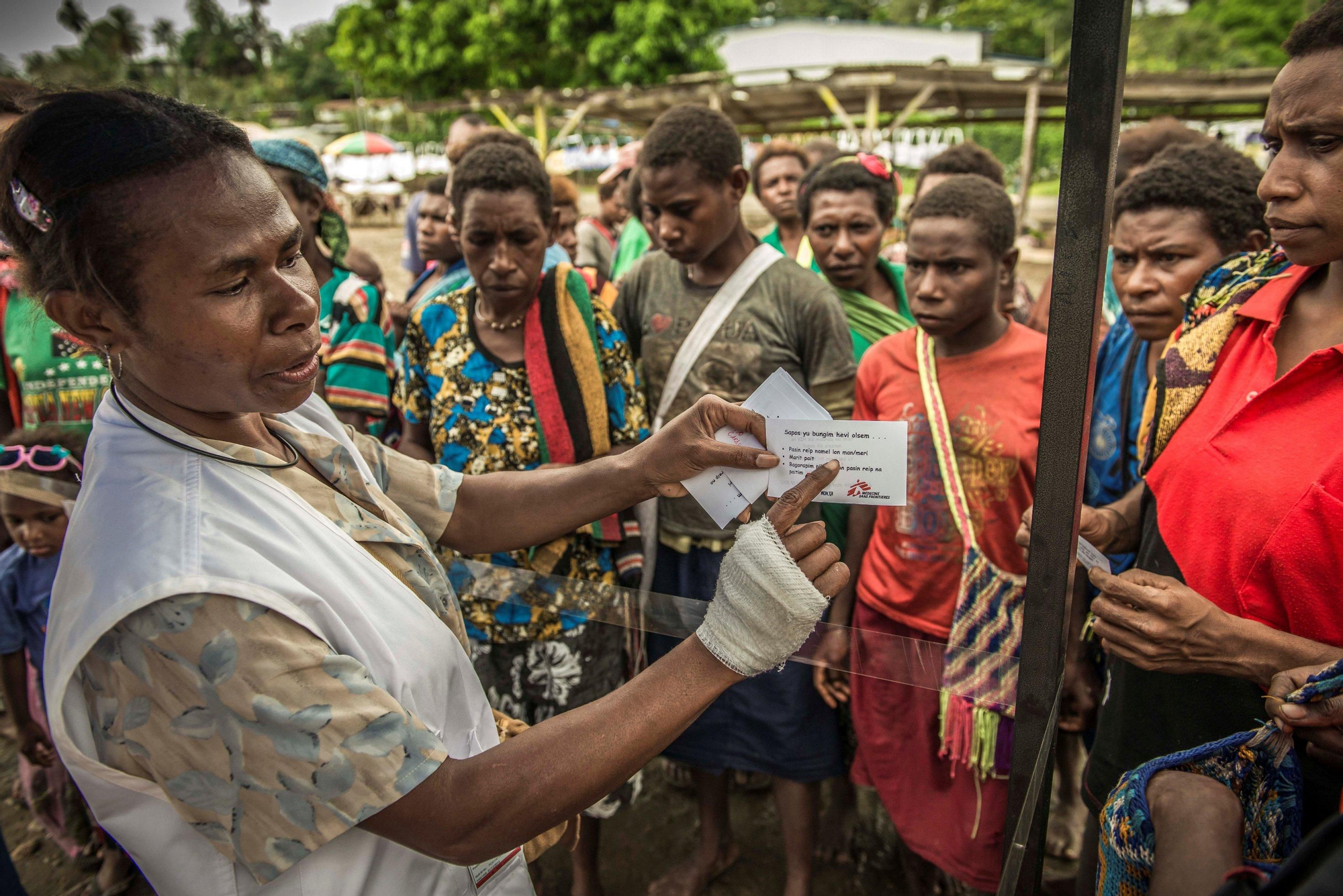 Marilyn Yull, agente comunitario. "Desde que empezamos a promover la conciencia sobre esta tema entre la comunidad, las mujeres saben que deben ir al Centro de Apoyo Familiar”: Actividad de sensibilización en el mercado de Maprik. Fotografía: Yann Libessart/MSF