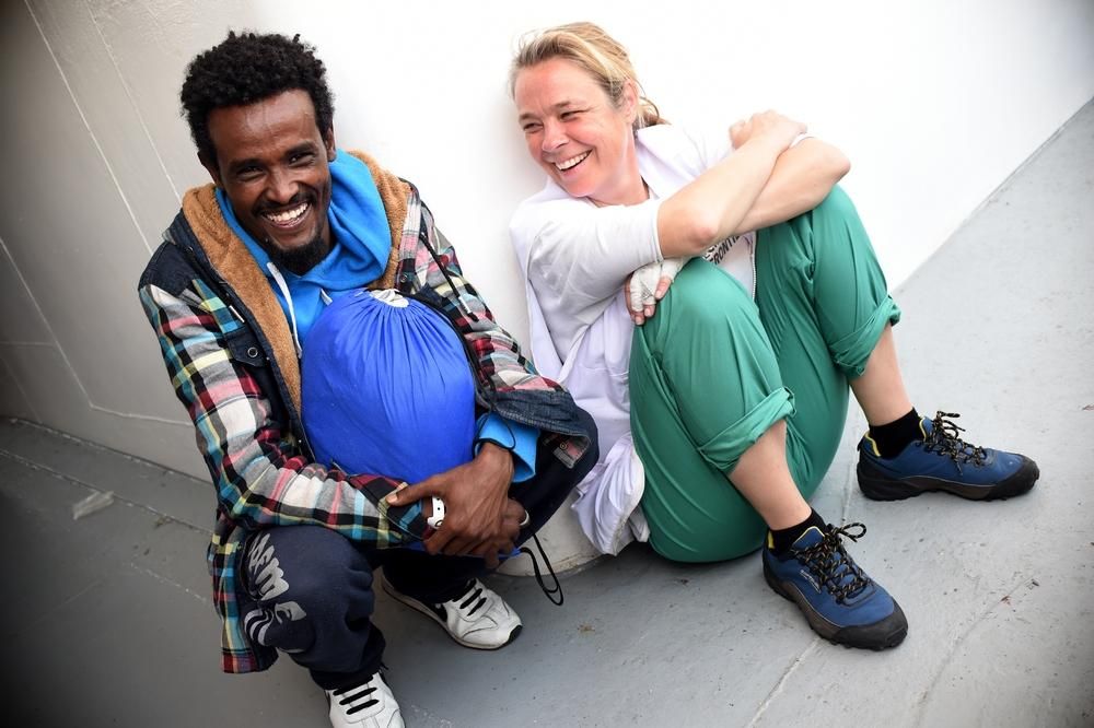 La doctora Erna Rijnierse bromea junto a una de las personas rescatadas a su llegada al puerto siciliano de Pozzallo, en Italia. Fotografía: Ikram N'gadi/MSF