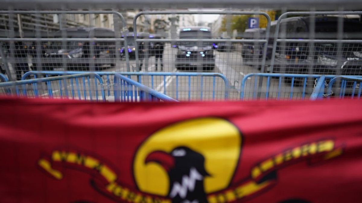 Una bandera franquista colgada por manifestantes de derecha en las vallas que rodean el Congreso de los Diputados en la primera jornada de la investidura de Pedro Sánchez
