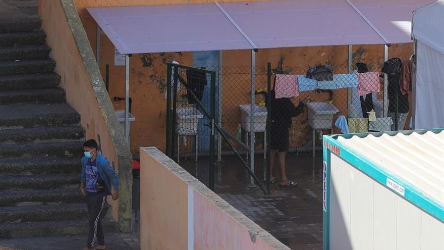 Varios jóvenes lavan la ropa en el campamento para migrantes de El Lasso