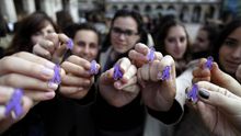 Un grupo de chicas muestra el símbolo de por los derechos de las mujeres.