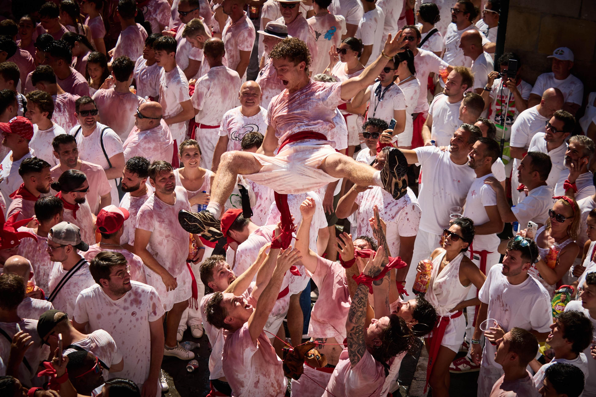 Jóvenes elevado en volandas en la plaza del Ayuntamiento en San Fermín
