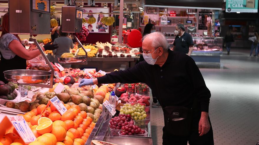 Un cliente señala la pieza de fruta que quiere en una frutería del Mercado Central de Valencia