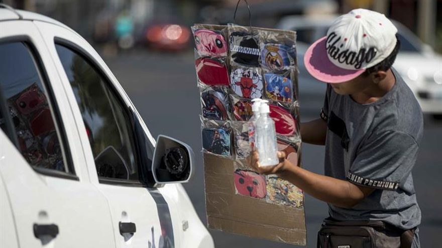 Un joven vende mascarillas de tela y gel antibacterial como medida de prevención contra la propagación del coronavirus en Managua (Nicaragua).