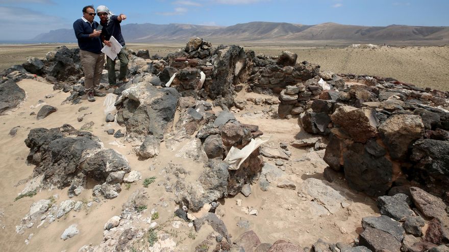 Luis Socorro escucha las explicaciones de Efraín Marrero, director de la excavación del yacimiento de Fiquinineo,  en Lanzarote