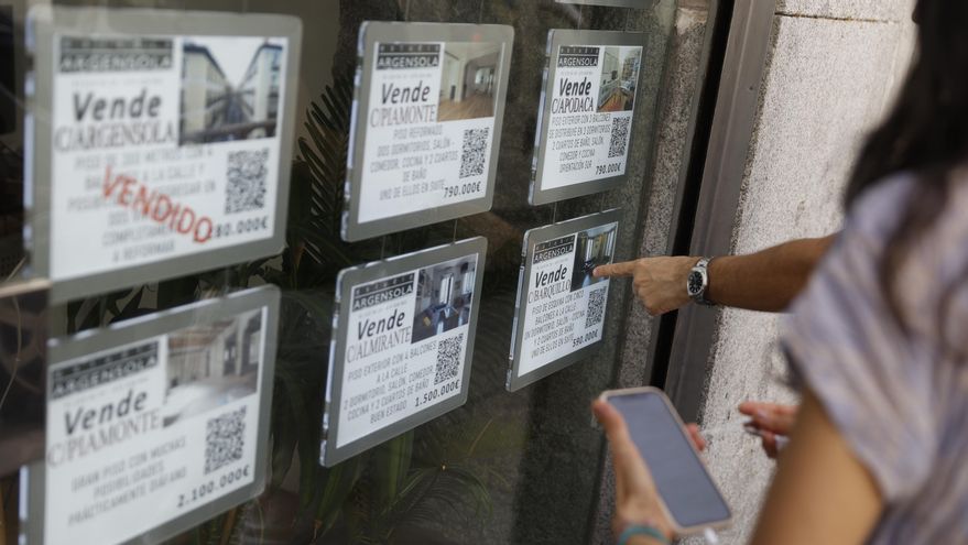 Unas personas se interesan por las ofertas de una inmobiliaria. EFE/ Mariscal
