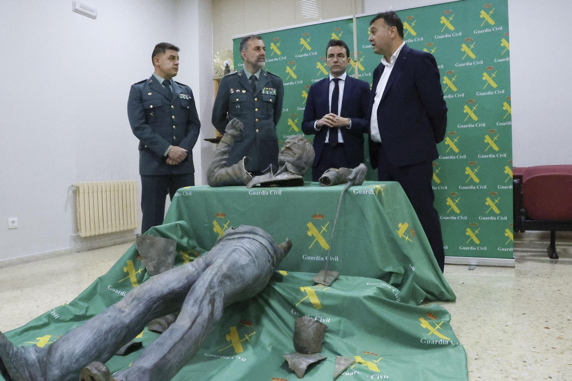 En la imagen, el alcalde de Medio Cudeyo, Pedro Pérez; el delegado del Gobierno en Cantabria, Pedro Casares; el teniente de la Guardia Civil en Cantabria, Julio Postigo, y el capitán del grupo de delitos contra el Patrimonio, Alberto Fuertes, junto a la estatua despedazada.