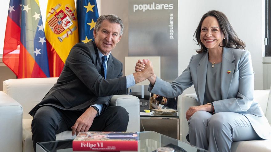 El líder del PP, Alberto Núñez Feijóo, con la opositora venezolana María Corina Machado durante un encuentro en la sede del partido, este viernes en Madrid. En primer término en la mesa, el libro 'Felipe VI. Perfiles de un decenio (2014-2024)'