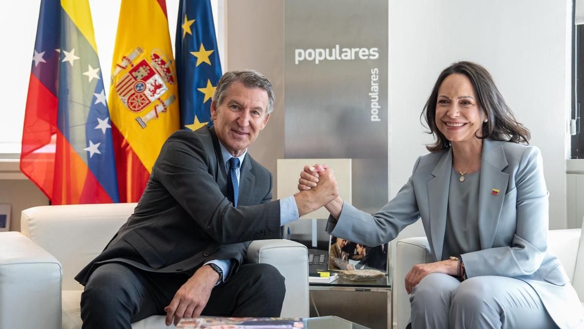 El líder del PP, Alberto Núñez Feijóo, con la opositora venezolana María Corina Machado durante un encuentro en la sede del partido, este viernes en Madrid. En primer término en la mesa, el libro 'Felipe VI. Perfiles de un decenio (2014-2024)'
