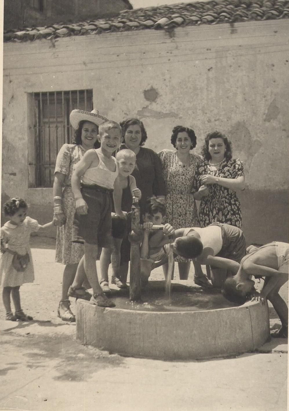 Grupo de mujeres y niños refrescándose en una fuente. Yunquera de Henares (Guadalajara). Años 50. Fondo Los Legados de la Tierra. Archivo de la Imagen de Castilla-La Mancha.