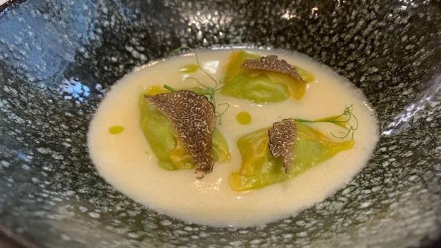 Pasta rellena de guisantes sobre caldo de jamón