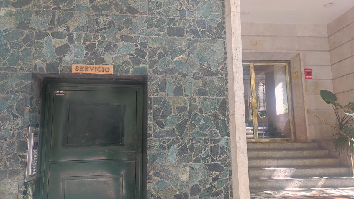 Puerta del servicio y portal principal en el edificio del ático adquirido por el Gobierno de Ayuso en Chamberí.