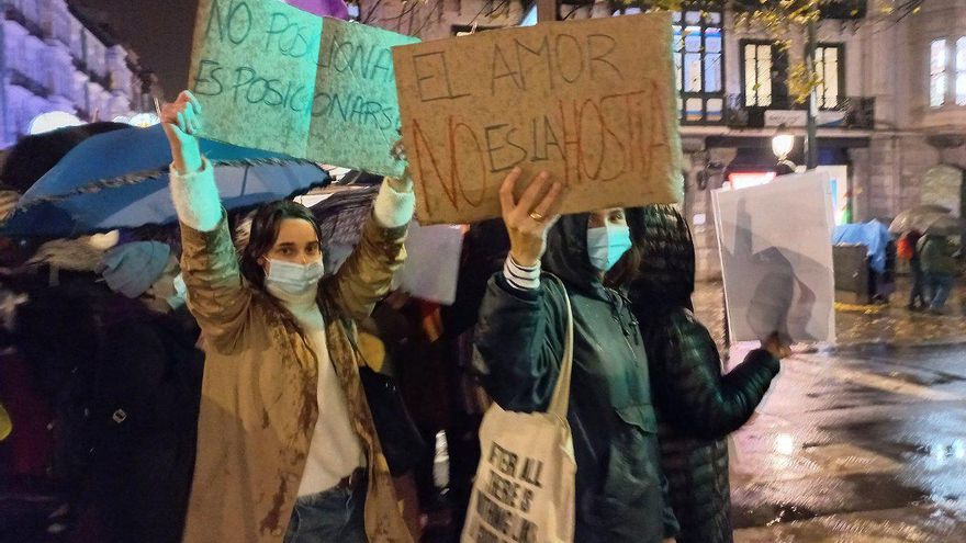 Amets y Elena con sus carteles en los que se lee "No posicionarse es posicionarse" y "El amor no es la hostia"